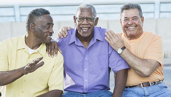 Three multi-ethnic senior men on bench outdoors